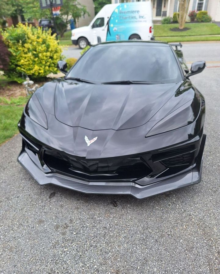 A black sports car is parked in a garage.