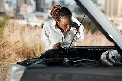 Person inspecting a vehicle after an accident while using a phone, likely calling for assistance