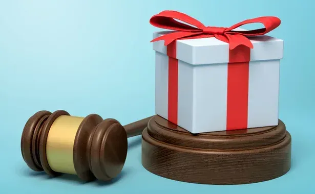 A judge's gavel with a neatly wrapped gift box placed on top of it
