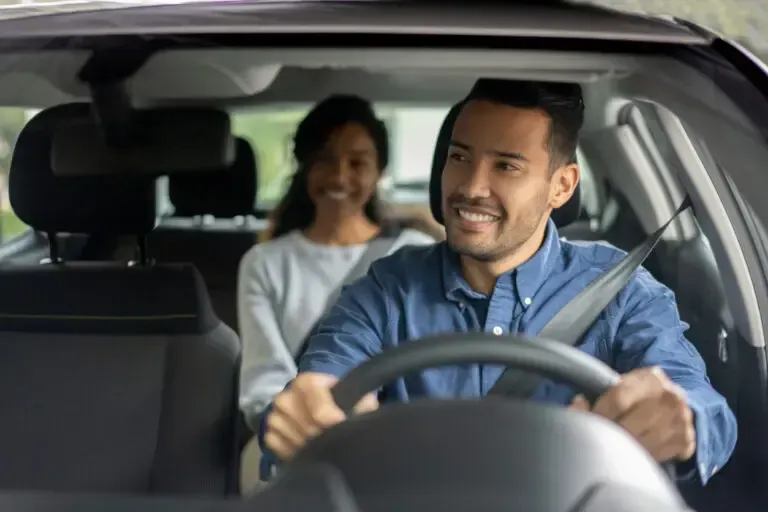 Car driver with a passenger sitting in the back seat, both visible inside the vehicle. Car driver with a passenger sitting in the back seat, both visible inside the vehicle.