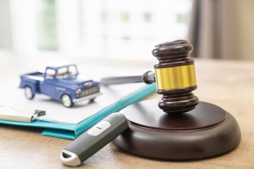 Judge's gavel resting beside a clipboard with legal documents on a wooden table