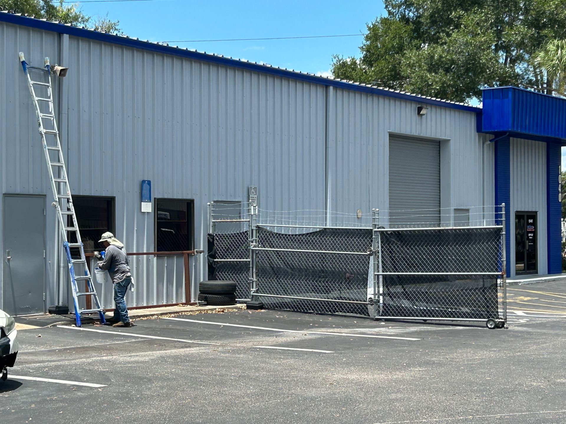 A man standing on a ladder in front of a building