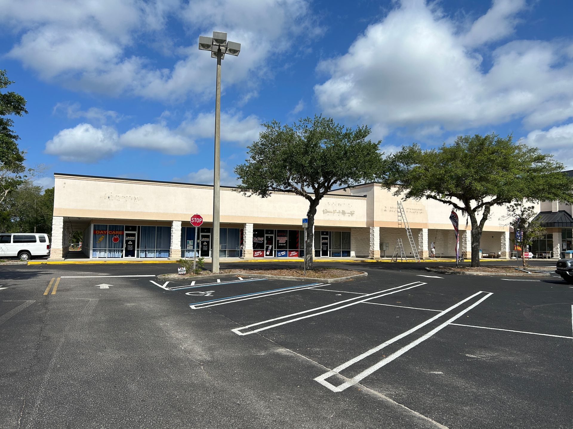 A parking lot with cars parked in front of a shopping center.