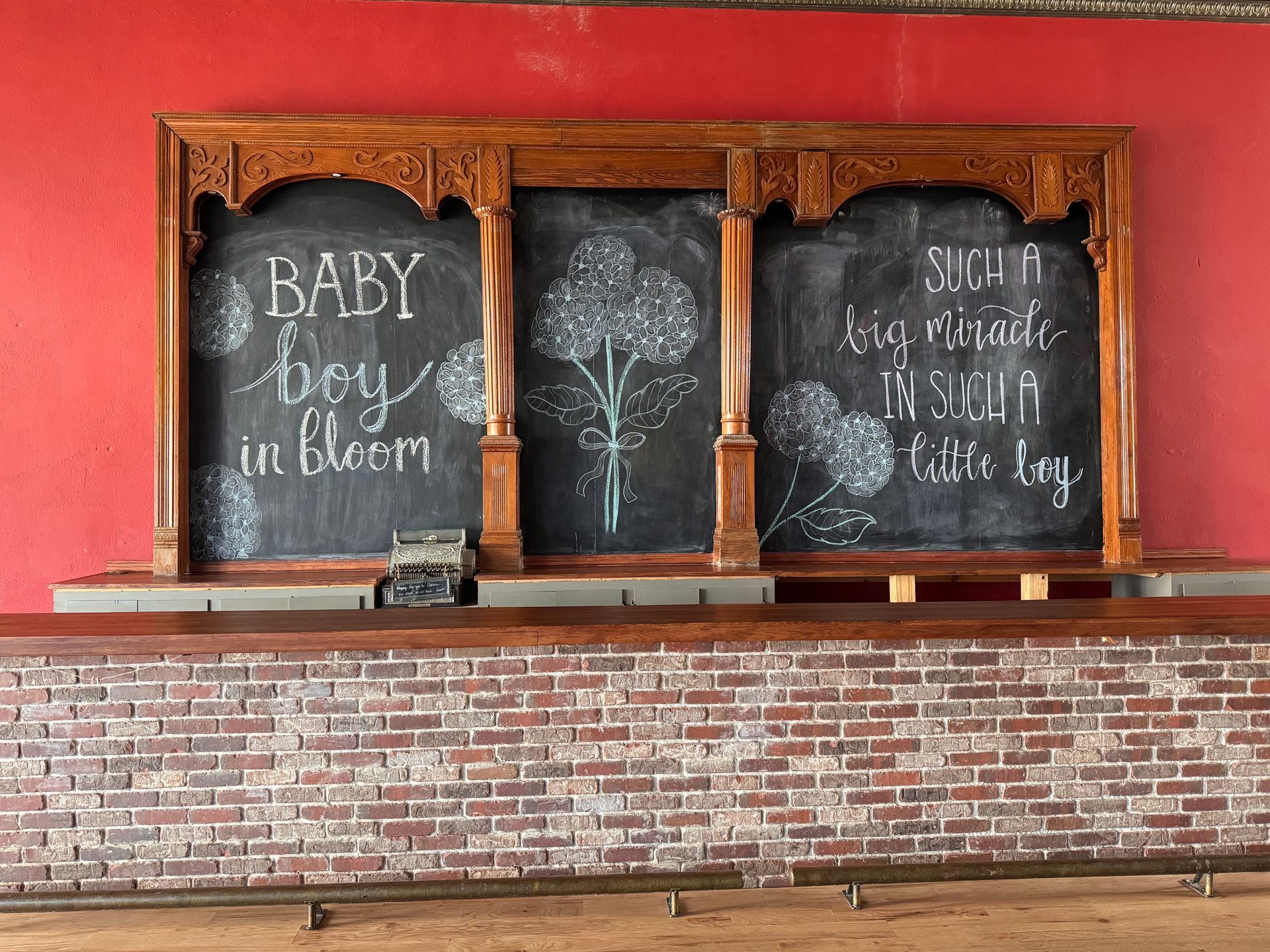 Vintage brick fireplace with chalkboard panels and ornate wood frame against a red wall