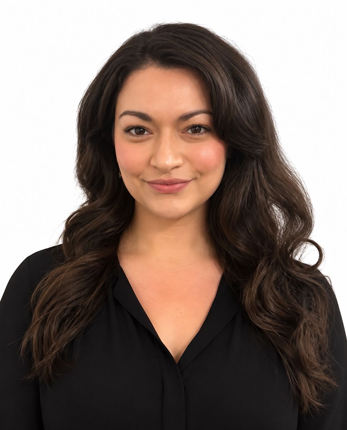 A woman in a black dress is standing in front of a white wall.