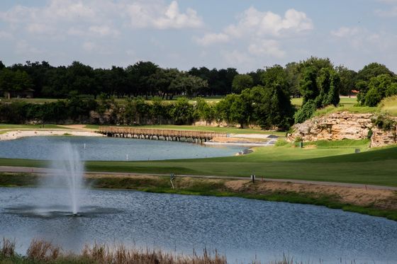 A golf course with a fountain in the middle of it