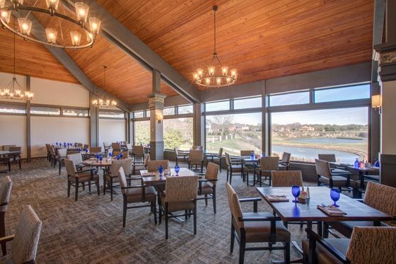 A large dining room with tables and chairs and a view of a lake.