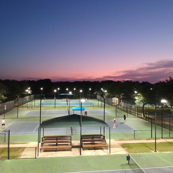 An aerial view of a tennis court at night