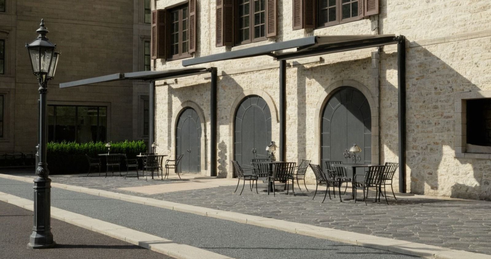 Edificio in pietra con porte ad arco e tavolini da caffè su una strada acciottolata e soleggiata.