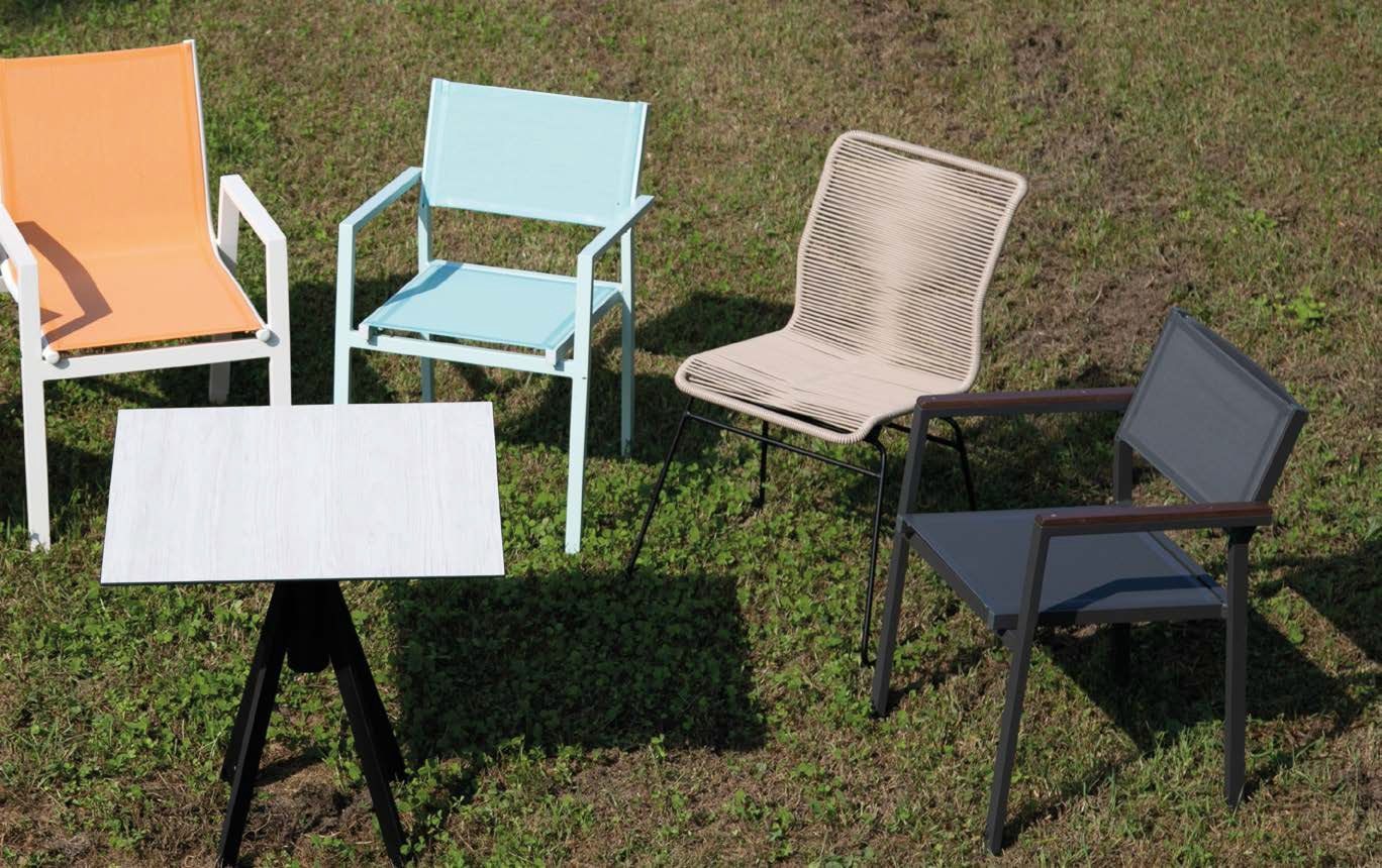 Cinque sedie da giardino disposte intorno a un tavolino sull'erba, nei colori arancione, blu, beige e nero.