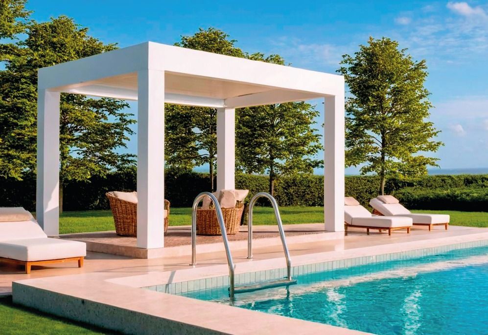 Moderno patio a bordo piscina con gazebo bianco, lettini e piscina turchese sotto un cielo azzurro.