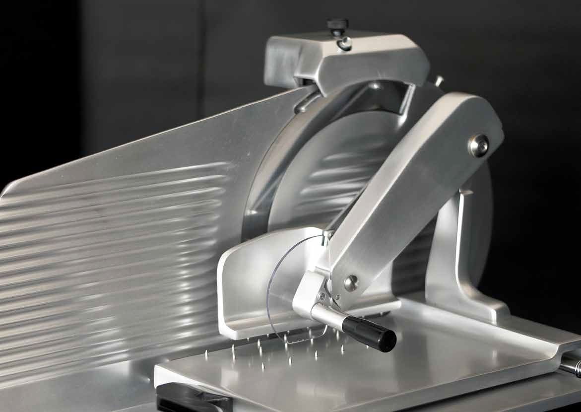 Dispositivo meccanico metallico con leva e piastra scanalata su una base, mostrato in primo piano.