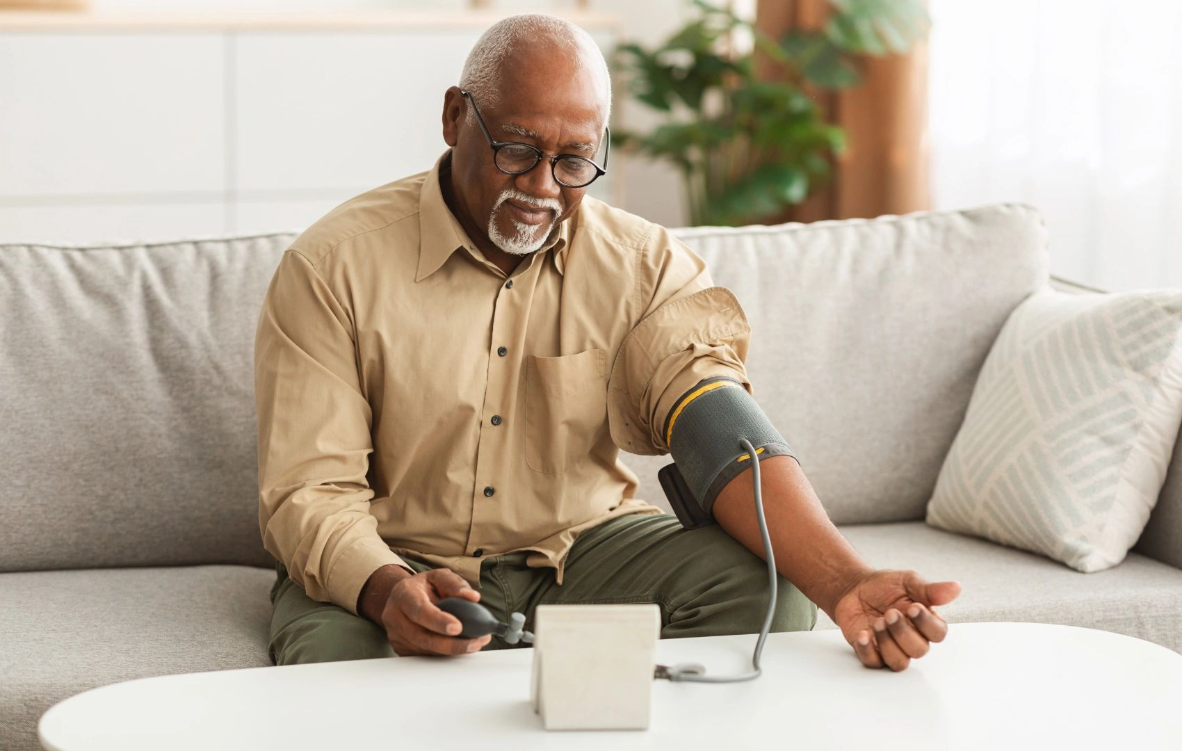 Person checking blood pressure at home on a couch
