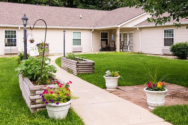 Single-story home with a curved walkway, green lawn, and flower pots in the front yard.