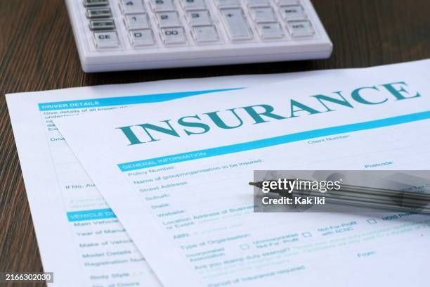 Insurance form on a desk beside a calculator, with a pen and paperwork visible.