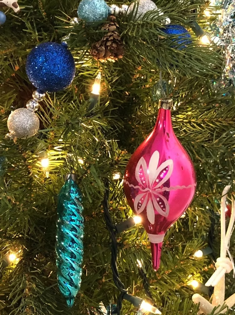 Christmas tree decorated with blue, silver, and pink ornaments.