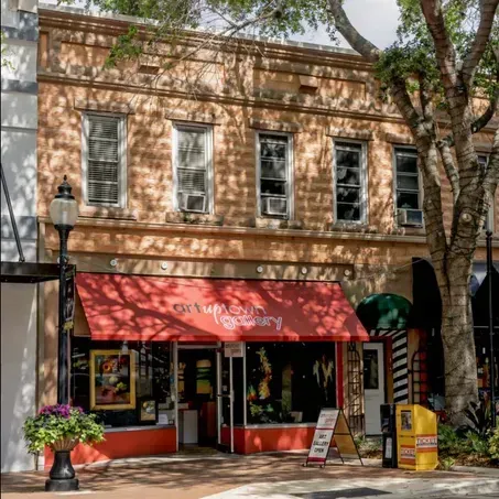 Two-story brick building with red awning labeled 
