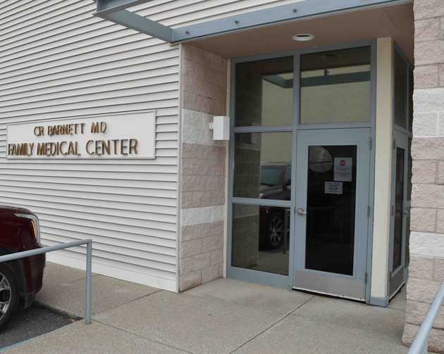 Entrance to a family medical center with glass doors and tan siding