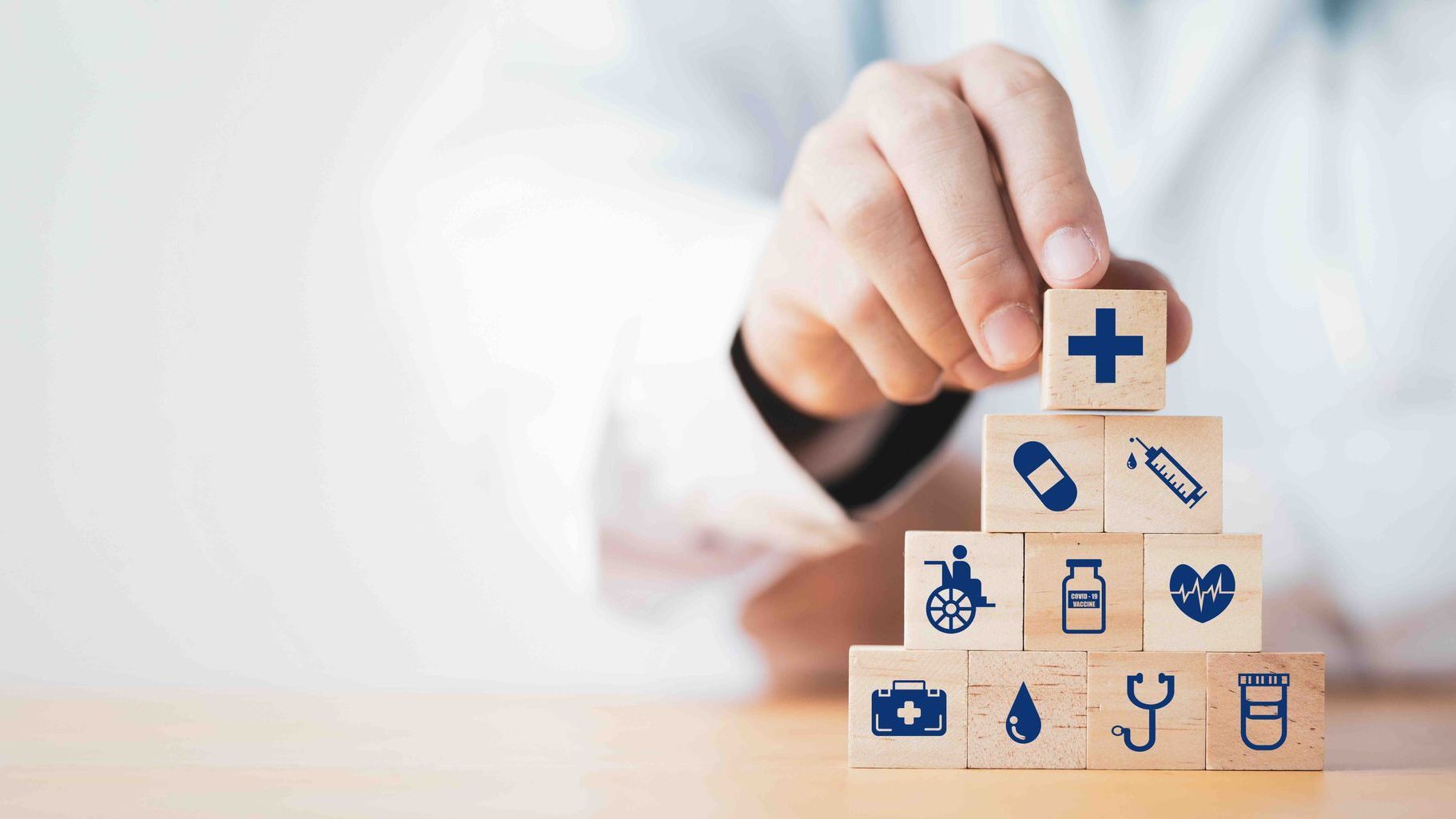 a doctor is stacking wooden blocks with medical icons on them.