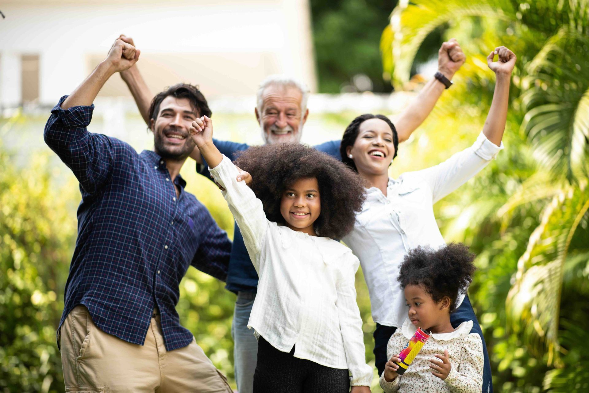 a family holding hands with their arms in the air