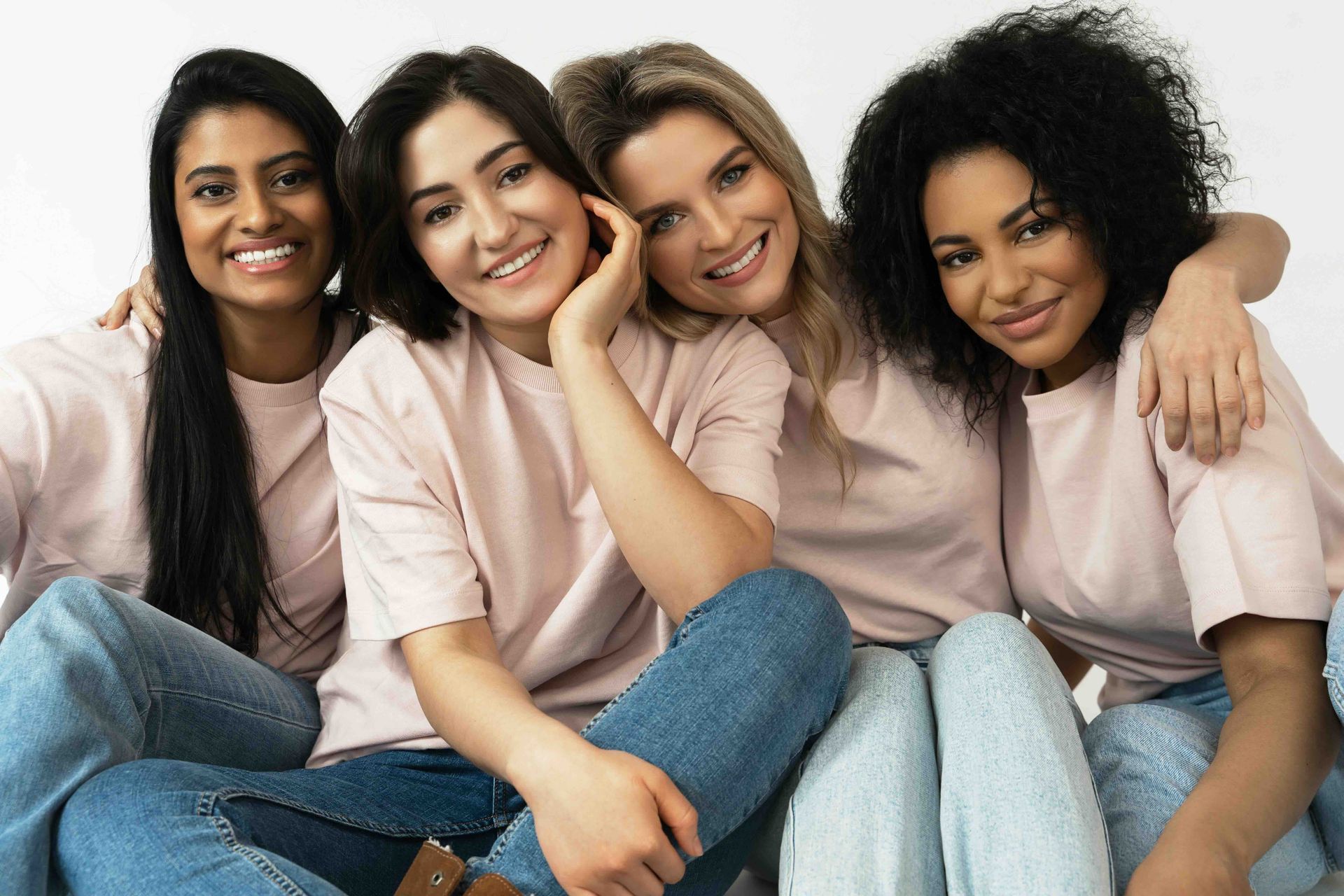 A group of women are sitting next to each other on the floor.