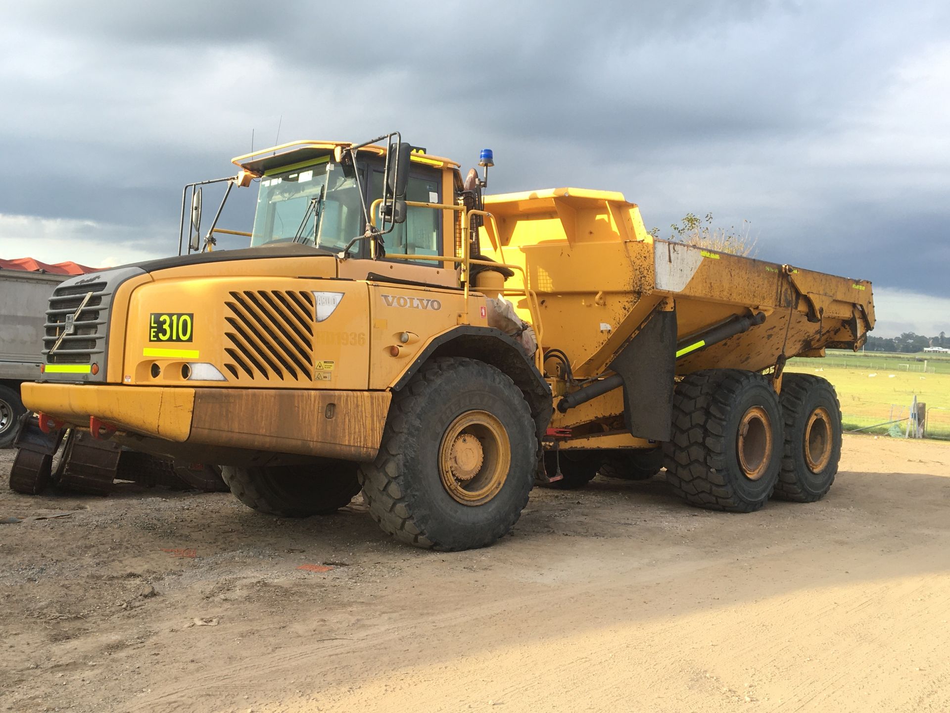 A Dump Truck is Driving Down a Dirt Road — Lantry Earthmoving in Phoenix Park, NSW