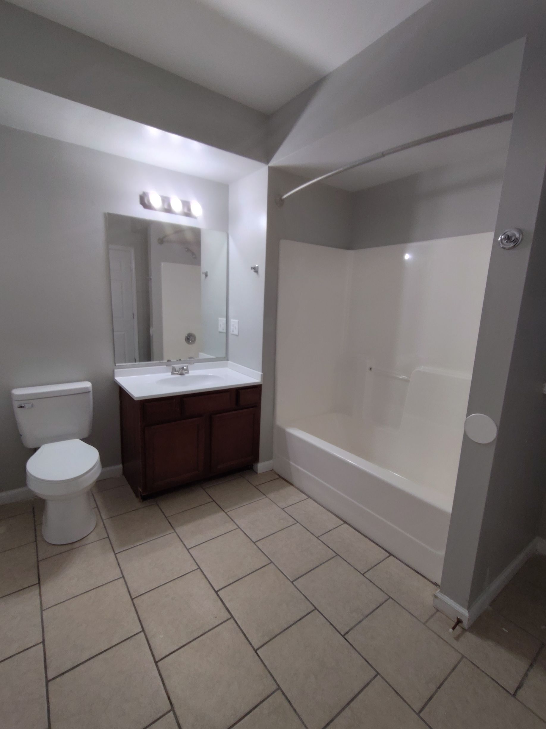 A bathroom with a toilet , sink , and shower.