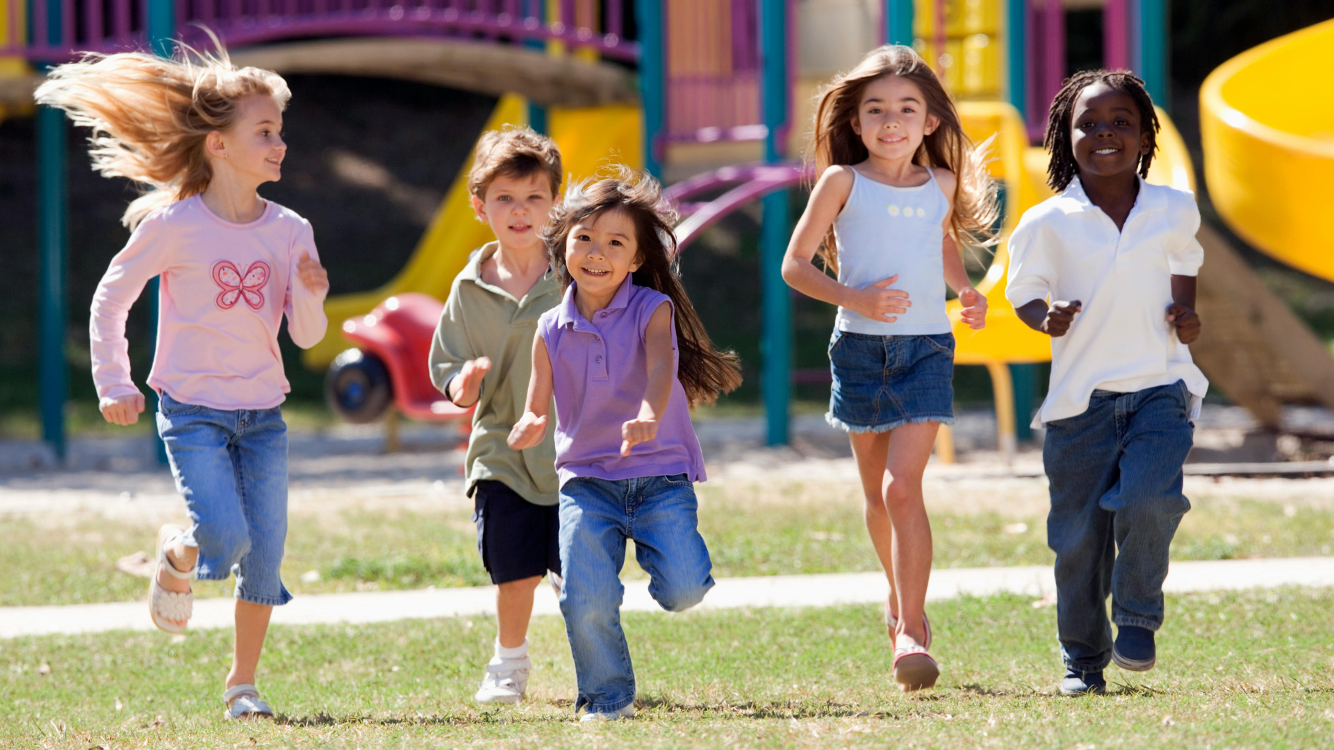 Children running together on a playground in bright daylight