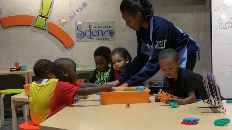 A group of children are playing with toys in a classroom with a sign that says science