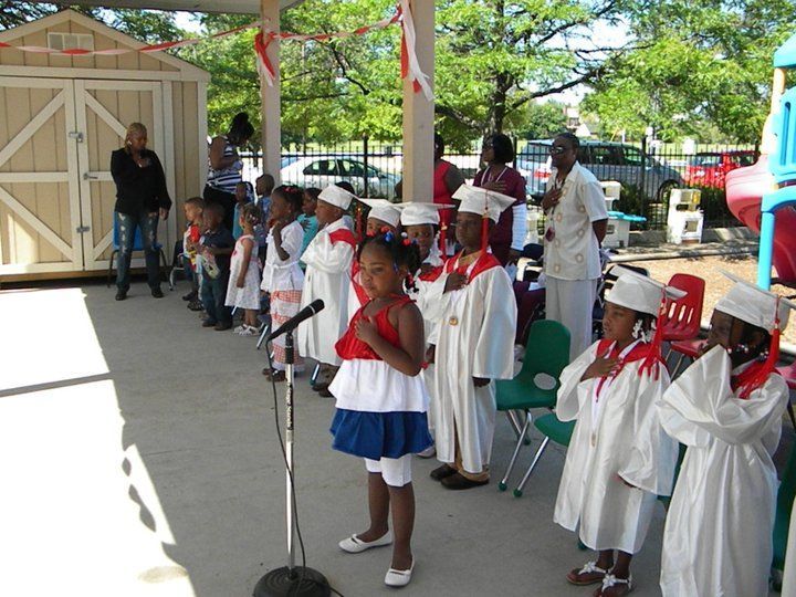 A girl in a red white and blue dress sings into a microphone