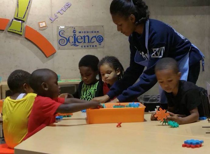 Teacher helps children play with blocks at a classroom table