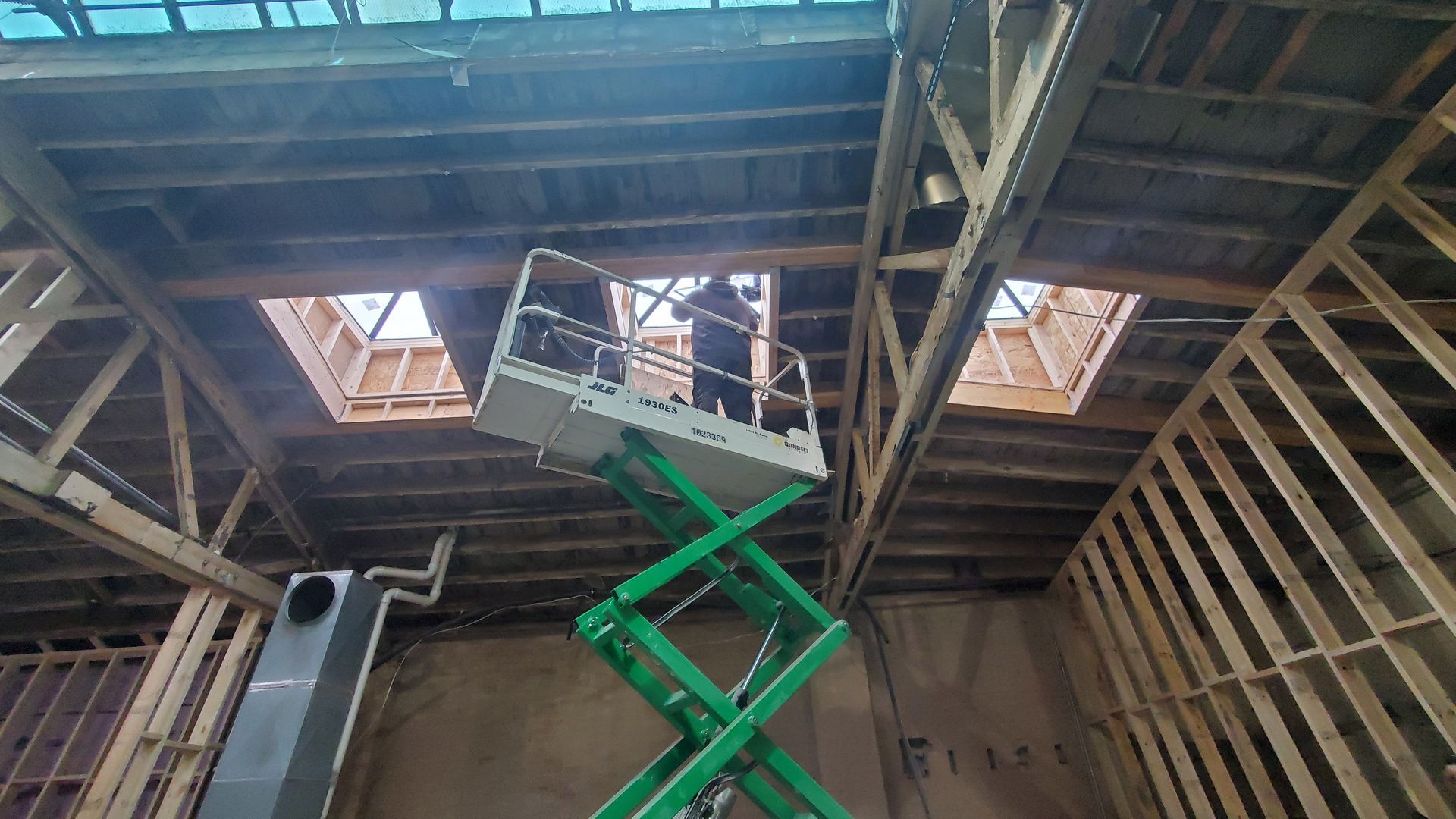 Heavy Equipment Machines A Repairman Installing a Skylight Using an Electric Scissor Lift