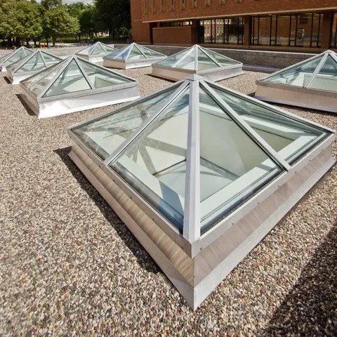 A row of pyramid shaped skylights on the roof of a building