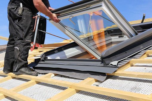 A Professional Man Installing a New Skylight on a Roof