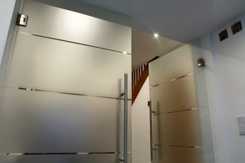 A Glass Door with A Staircase in The Background — Coastline Glass Pool Fencing in Forster, NSW