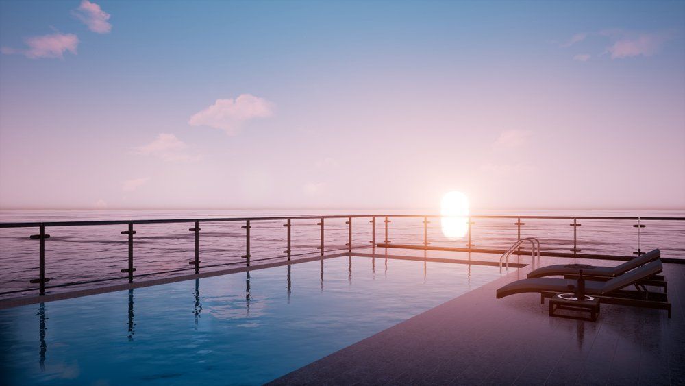 A Swimming Pool with A View of The Ocean at Sunset — Coastline Glass Pool Fencing in Hallidays Point, NSW