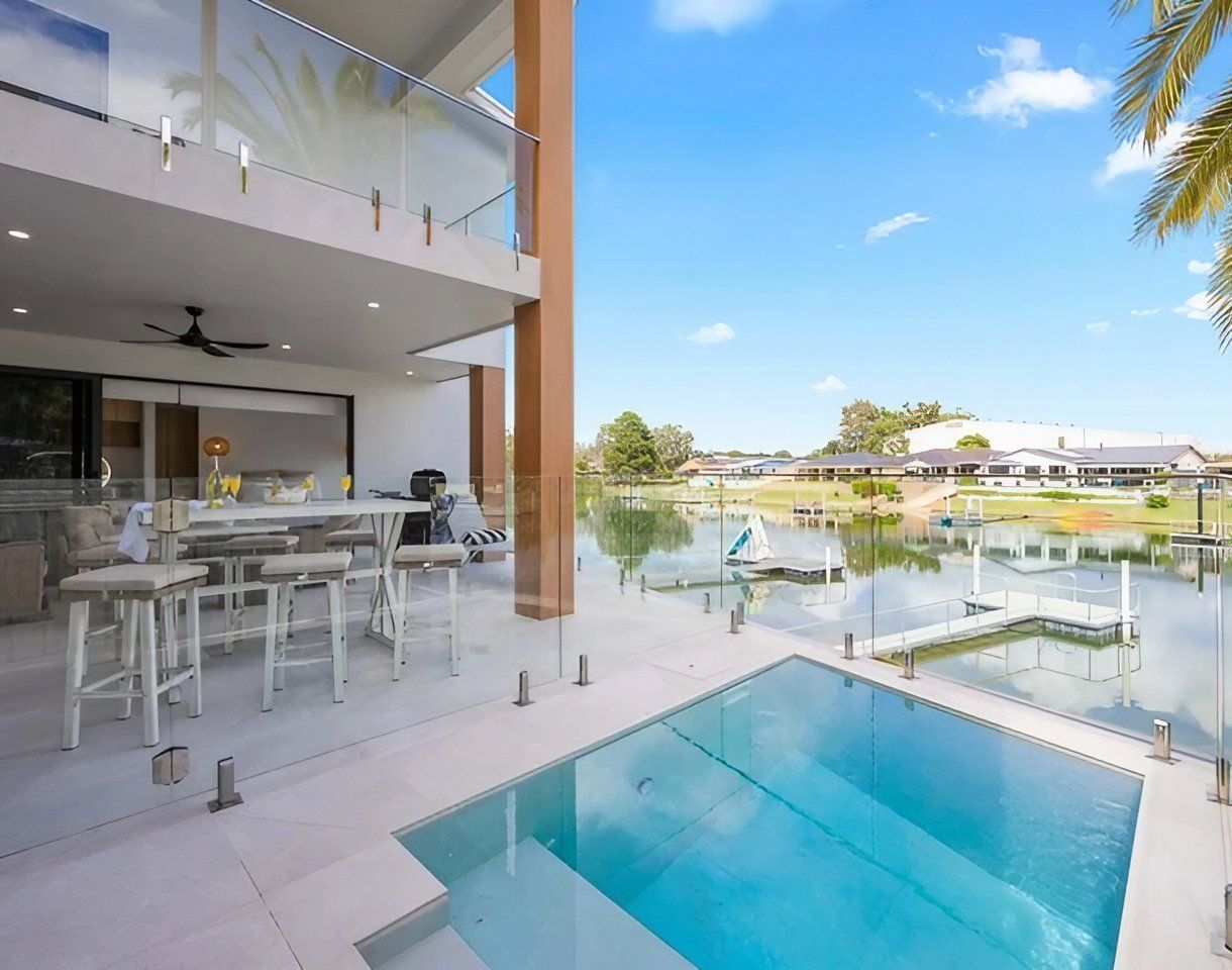 A Large Swimming Pool in The Backyard of A House — Coastline Glass Pool Fencing in Bulahdelah, NSW