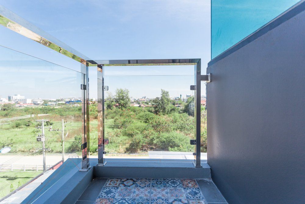 A Balcony with A Glass Railing and A View of A Field — Coastline Glass Pool Fencing in Taree, NSW