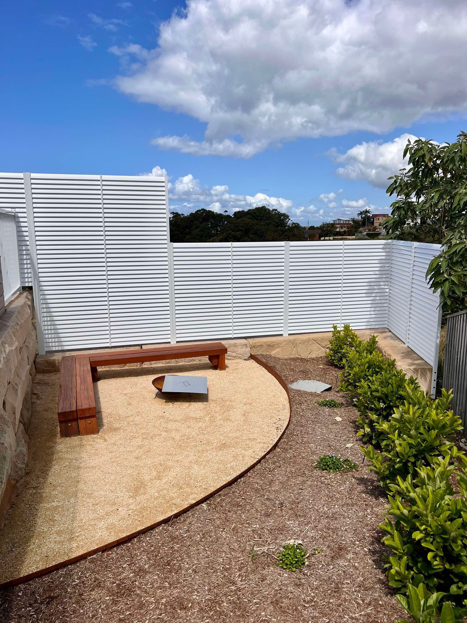 A Modern Outdoor Patio with A White Slatted Fence — Coastline Glass Pool Fencing in Old Bar, NSW