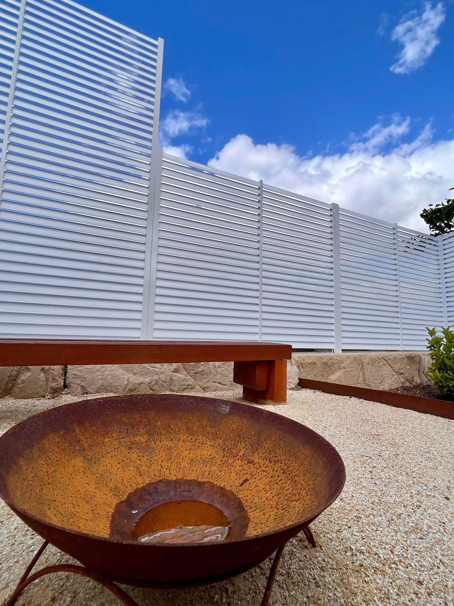 A Black Wrought Iron Fence Is Surrounded by Trees on A Sidewalk — Coastline Glass Pool Fencing in Old Bar, NSW