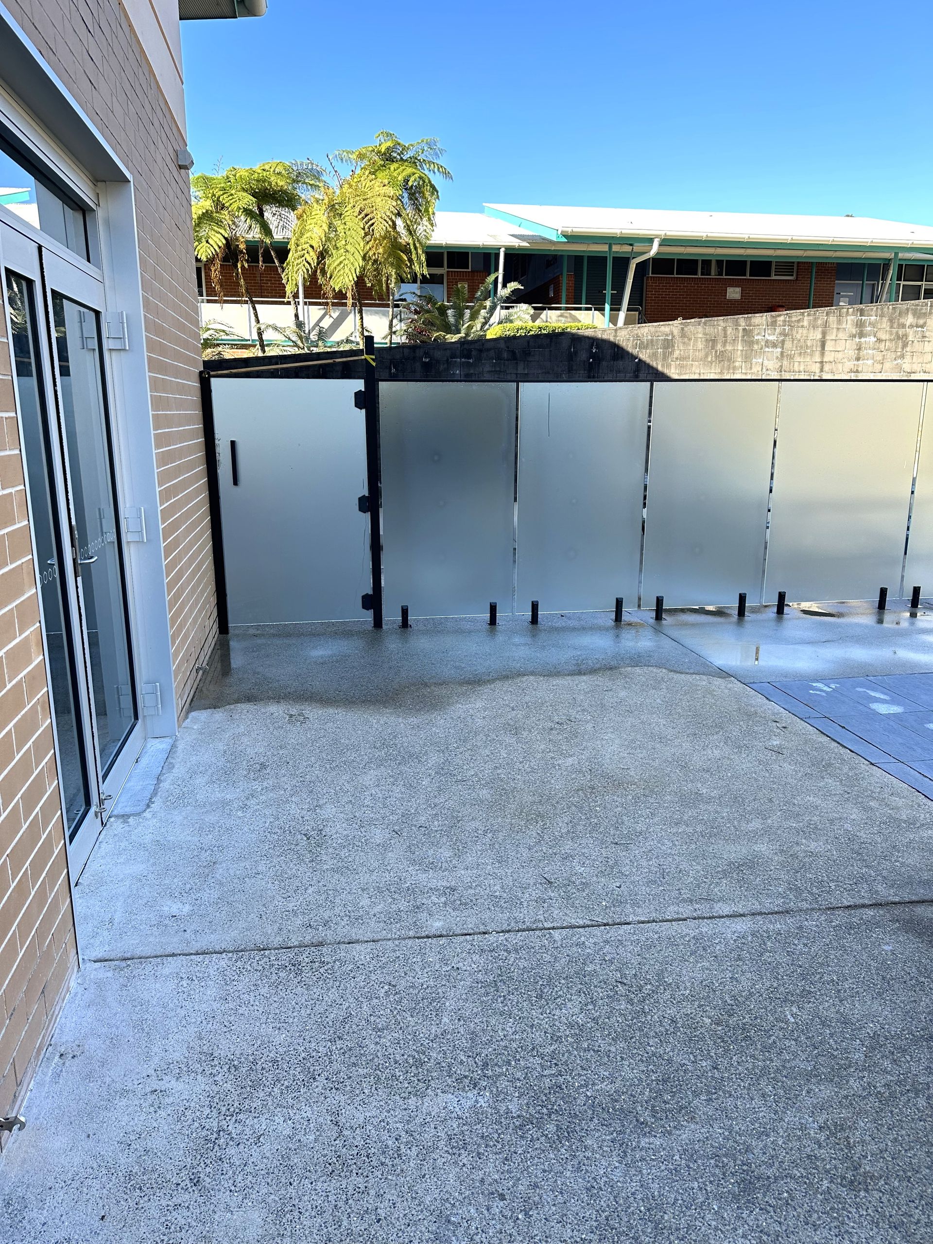 A Glass Door with A Staircase in The Background — Coastline Glass Pool Fencing in Old Bar, NSW