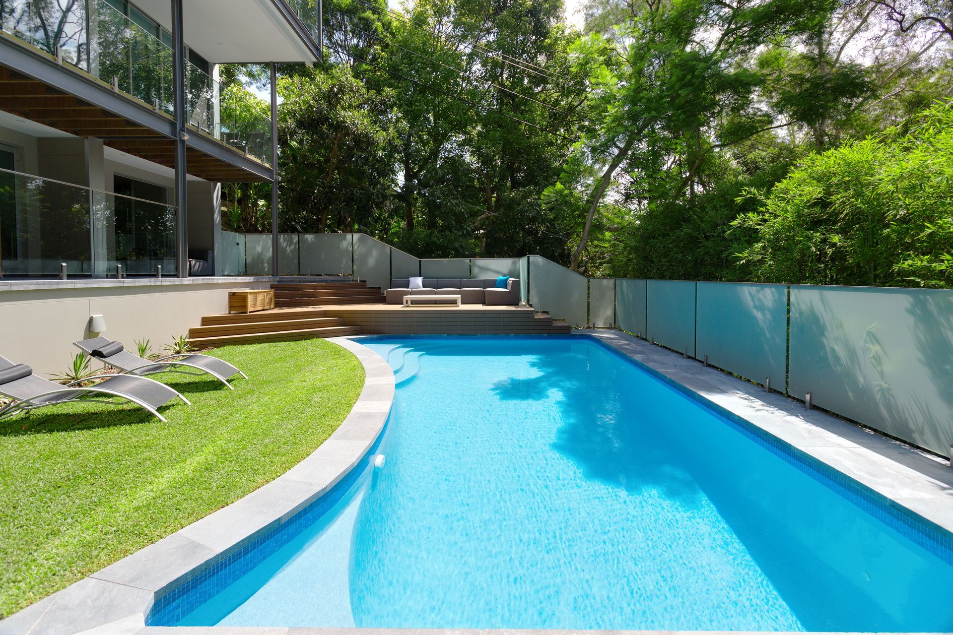 A Large Swimming Pool in The Backyard of A House — Coastline Glass Pool Fencing in Old Bar, NSW
