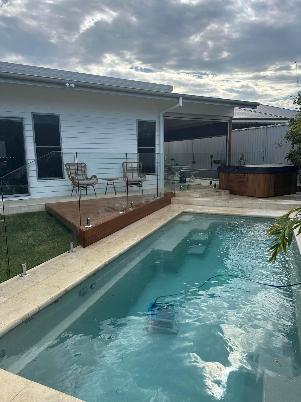 A Large Swimming Pool in Front of A House with A Hot Tub — Coastline Glass Pool Fencing in Old Bar, NSW