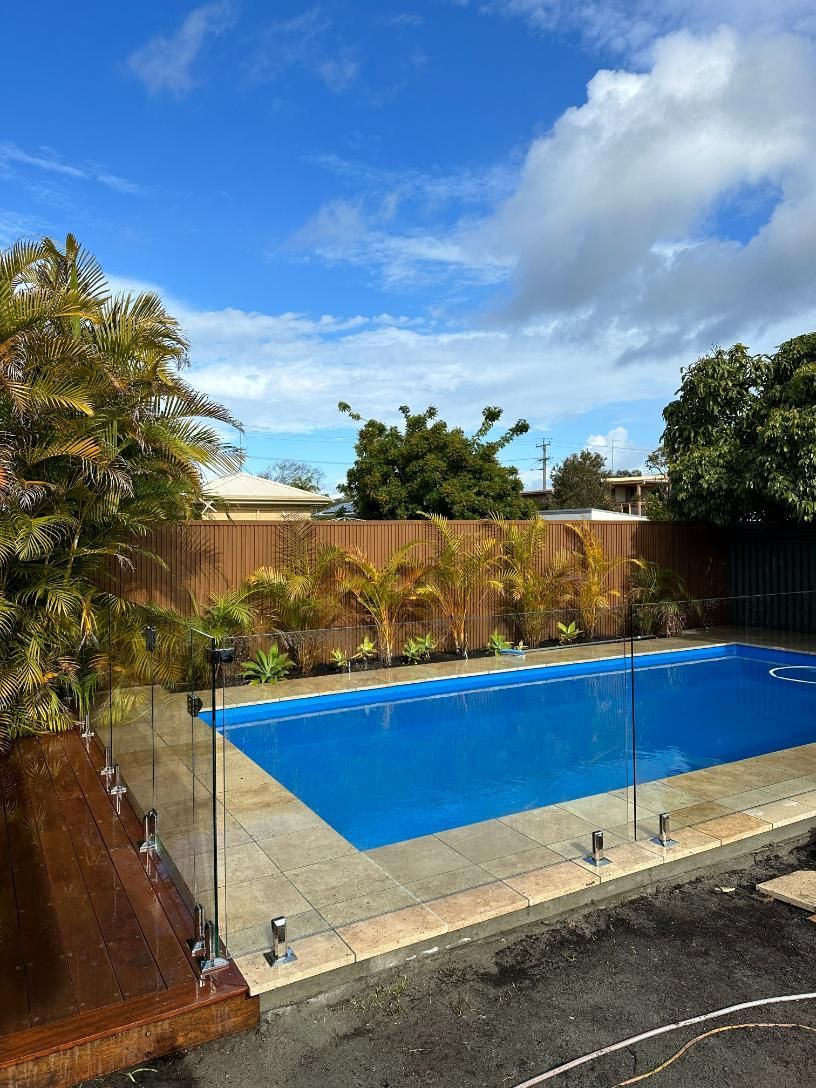 A Large Swimming Pool in A Backyard — Coastline Glass Pool Fencing in Old Bar, NSW