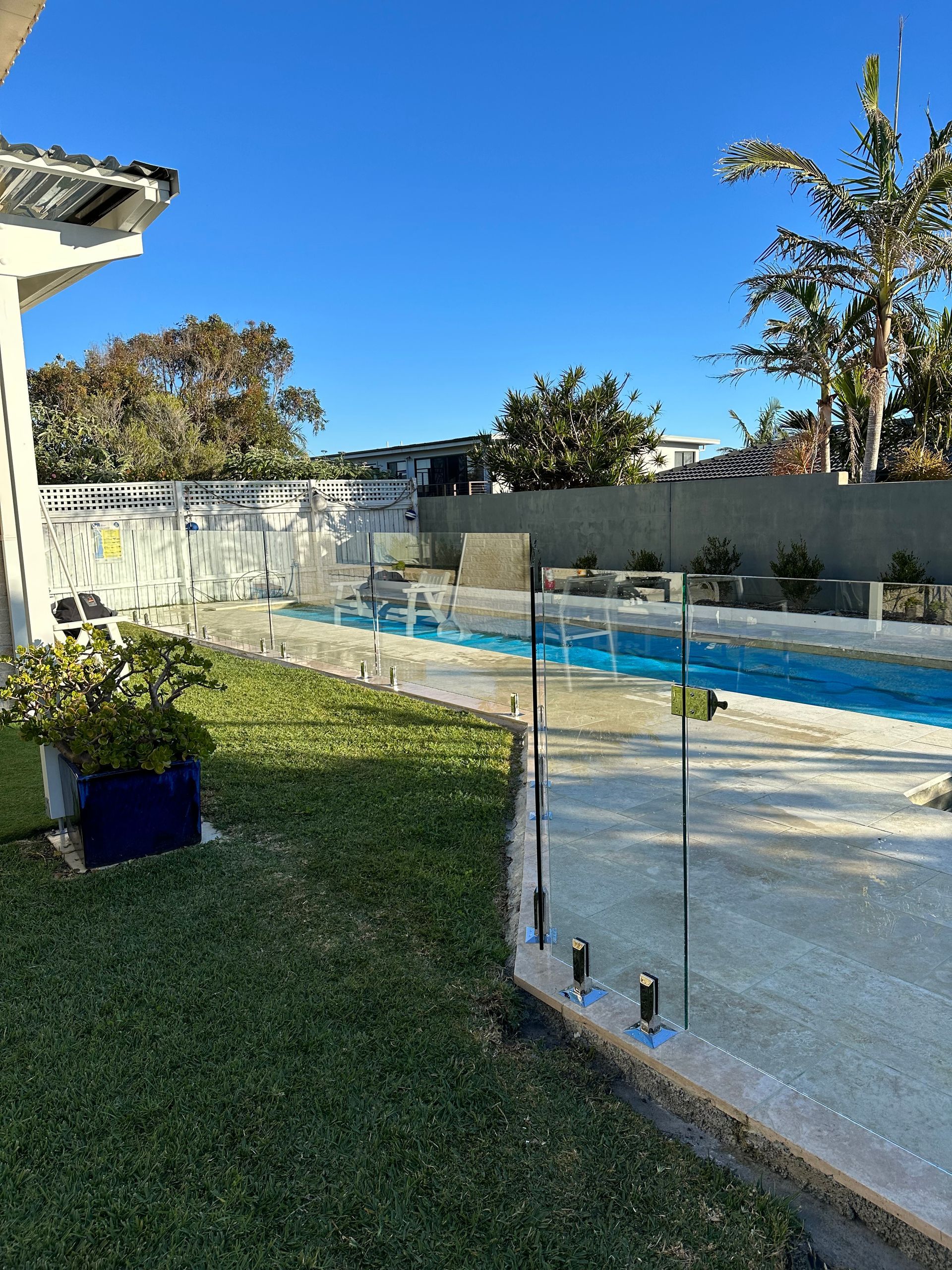 There Is a Swimming Pool in The Backyard of A House — Coastline Glass Pool Fencing in Old Bar, NSW