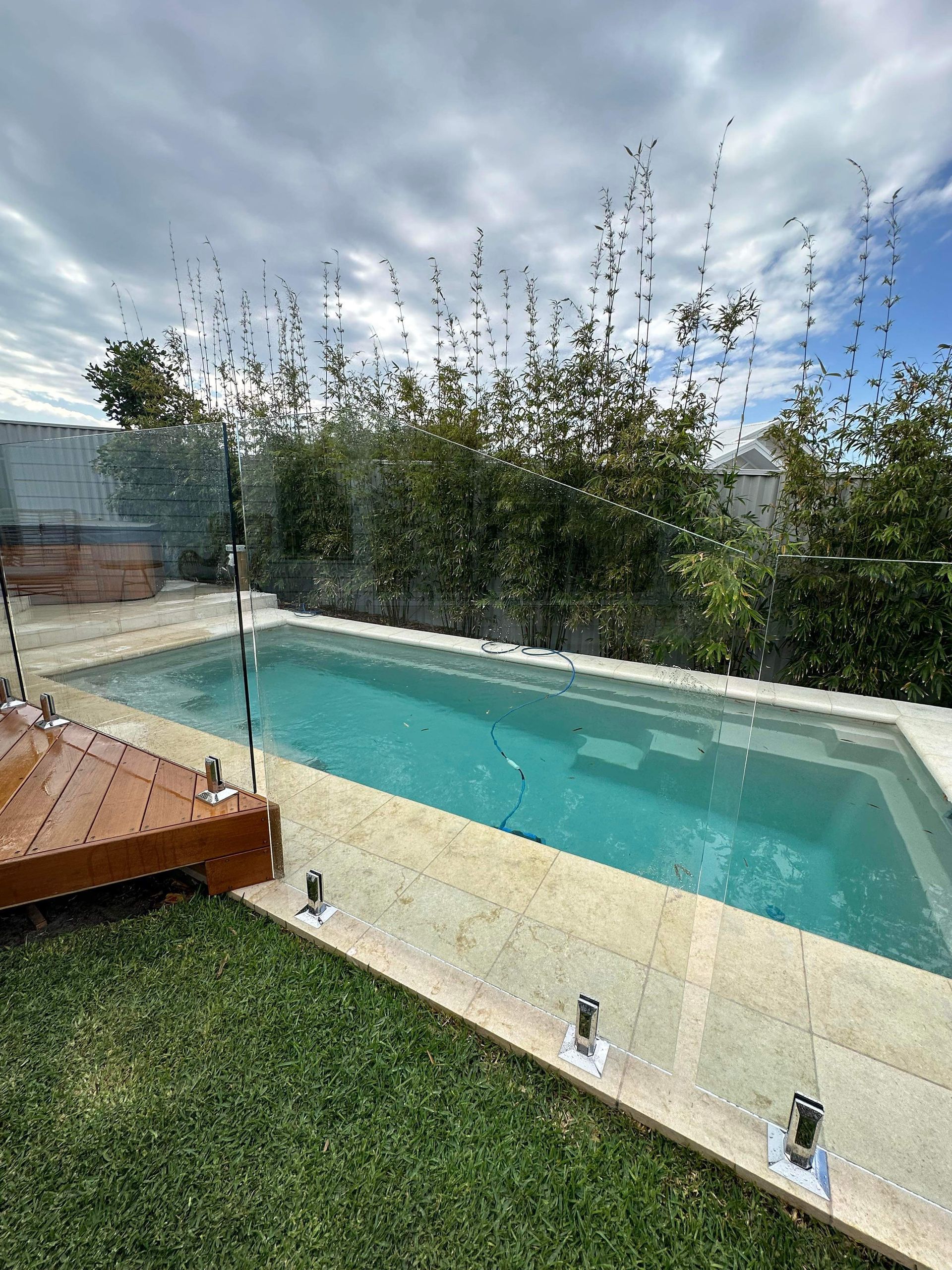There Is a Large Swimming Pool in The Backyard of A House — Coastline Glass Pool Fencing in Old Bar, NSW