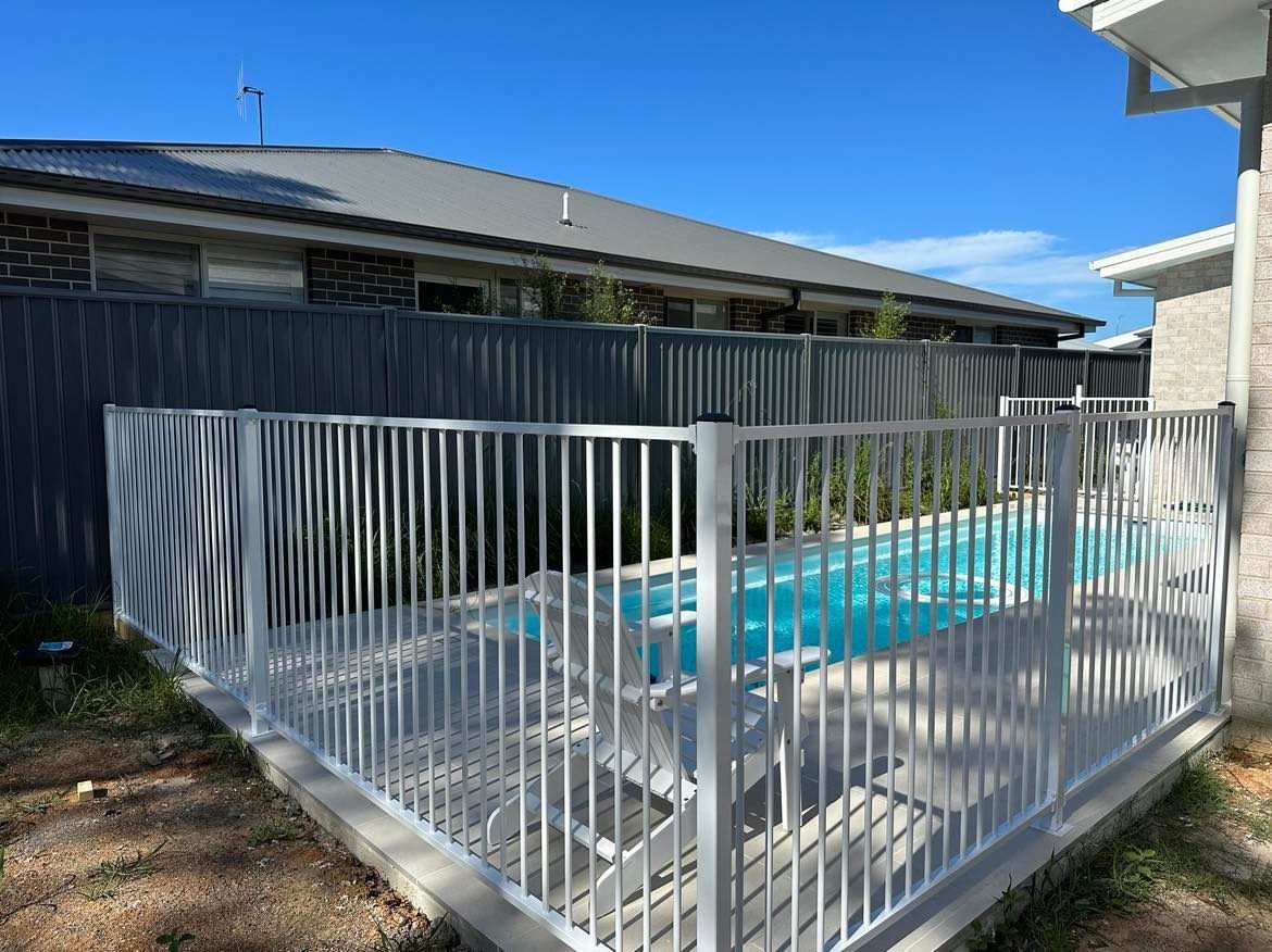 A Wrought Iron Fence Surrounds a Swimming Pool — Coastline Glass Pool Fencing in Gloucester, NSW