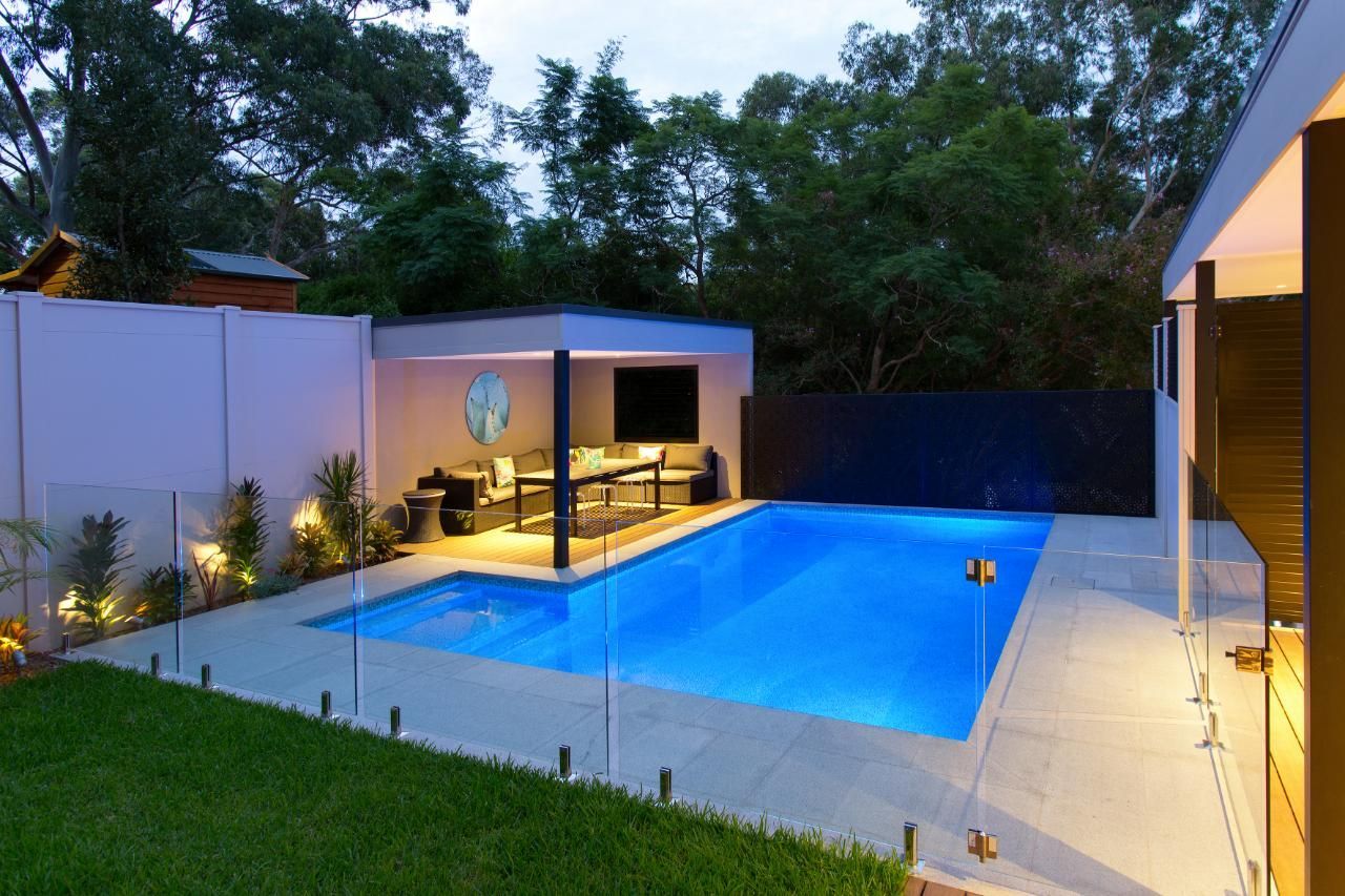 A Bright Blue Swimming Pool Sits Next to A Modern, Illuminated Outdoor — Coastline Glass Pool Fencing in Old Bar, NSW