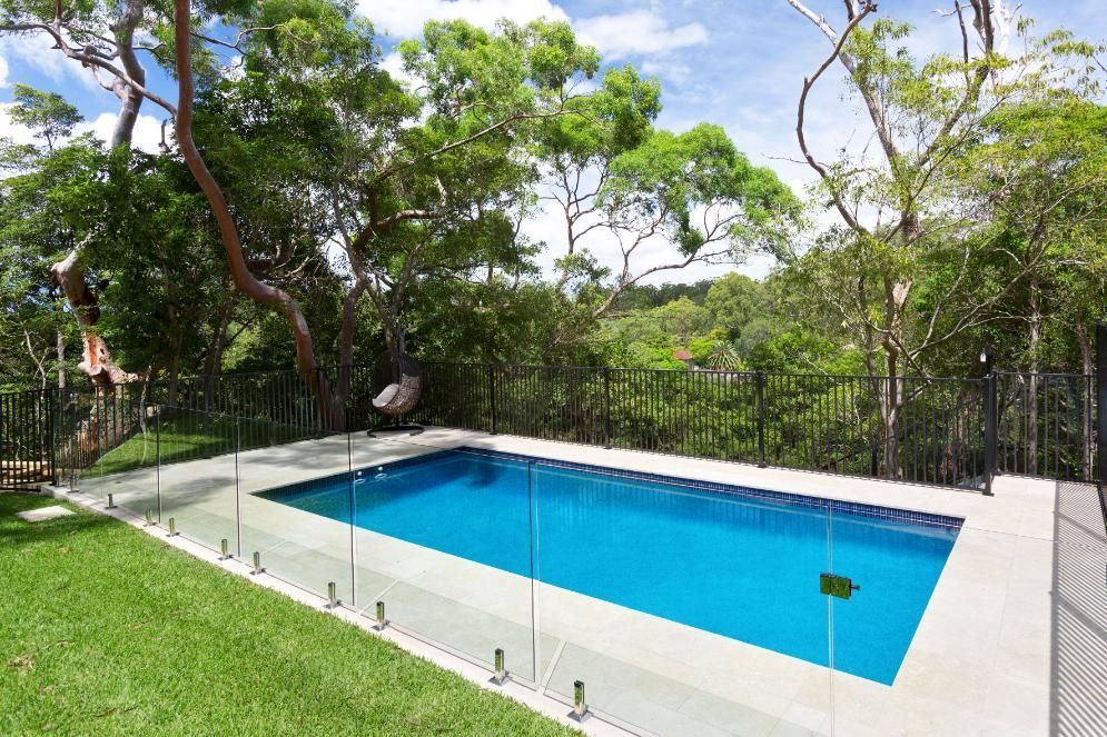 A Rectangular Swimming Pool with Blue Water and Light Stone Coping — Coastline Glass Pool Fencing in Old Bar, NSW