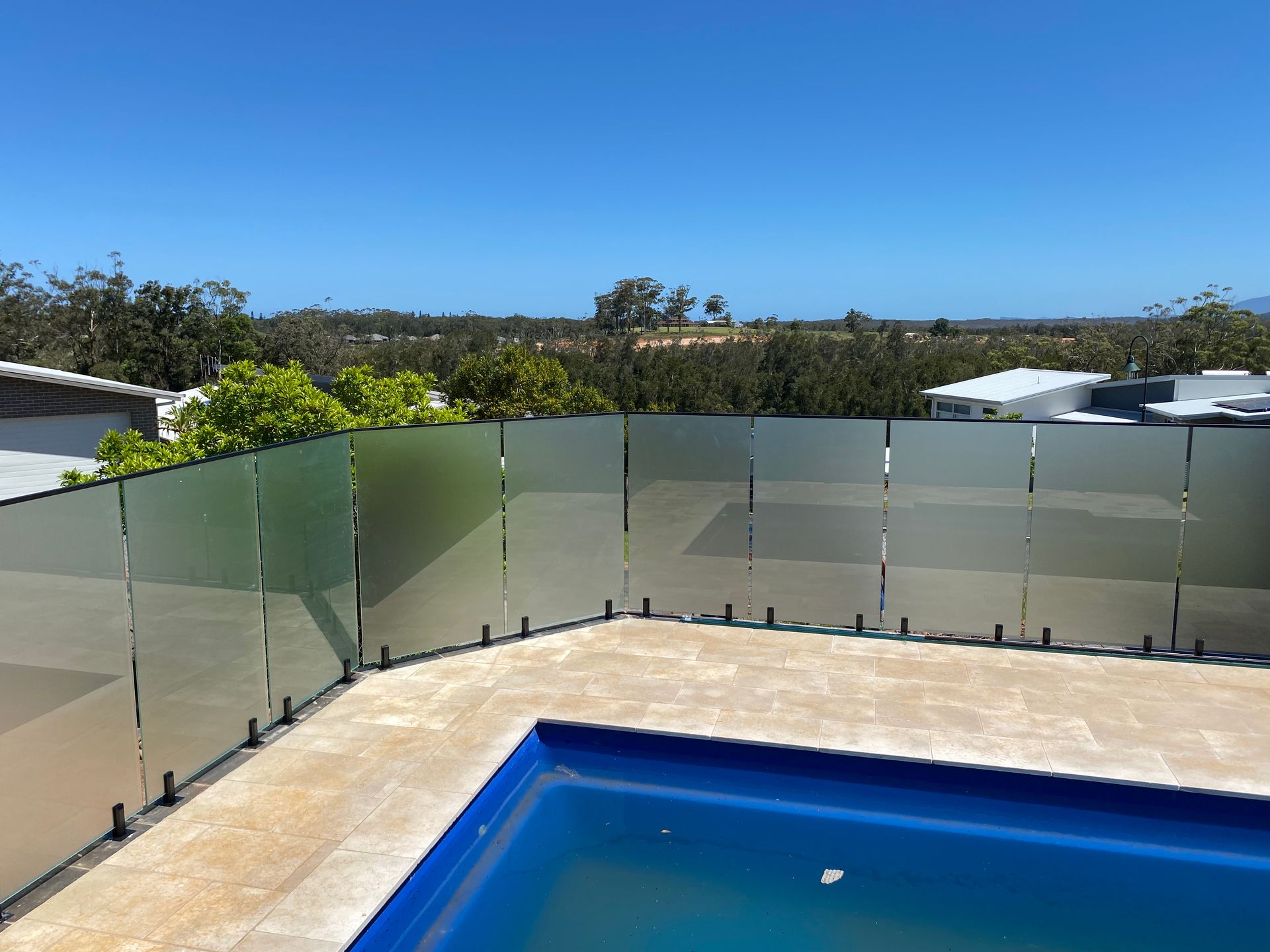 A Swimming Pool with A Glass Fence Around It — Coastline Glass Pool Fencing in Old Bar, NSW